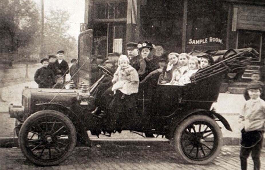 In black and white, Wojciech Mioducki and his wife in their automobile. 
