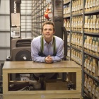 Annex manager, CJ Keough, attaches a safety harness when using the order picker to retrieve materials from the Annex shelves. 