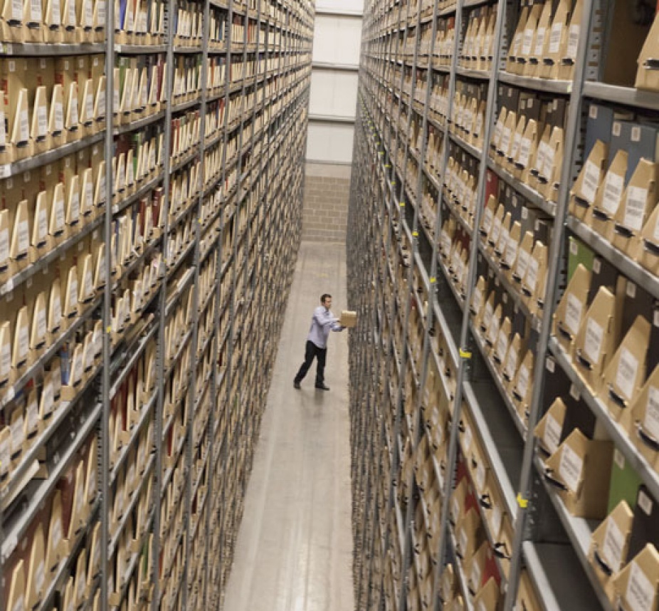 Long rows of adjustable, free-standing shelving units soar three stories high. 
