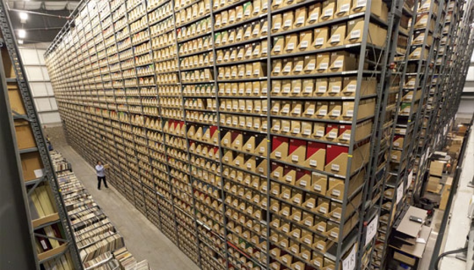 Neatly-stacked trays on each shelf hold low-use print materials, many of which are now accessible in digital format. 