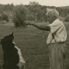 In black and white, Robert Frost with his dog, Gillie. 