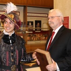 Two people, one in Shakespearean-esc outfit, and the other in modern clothing, both holding a Shakespeare Folio. 