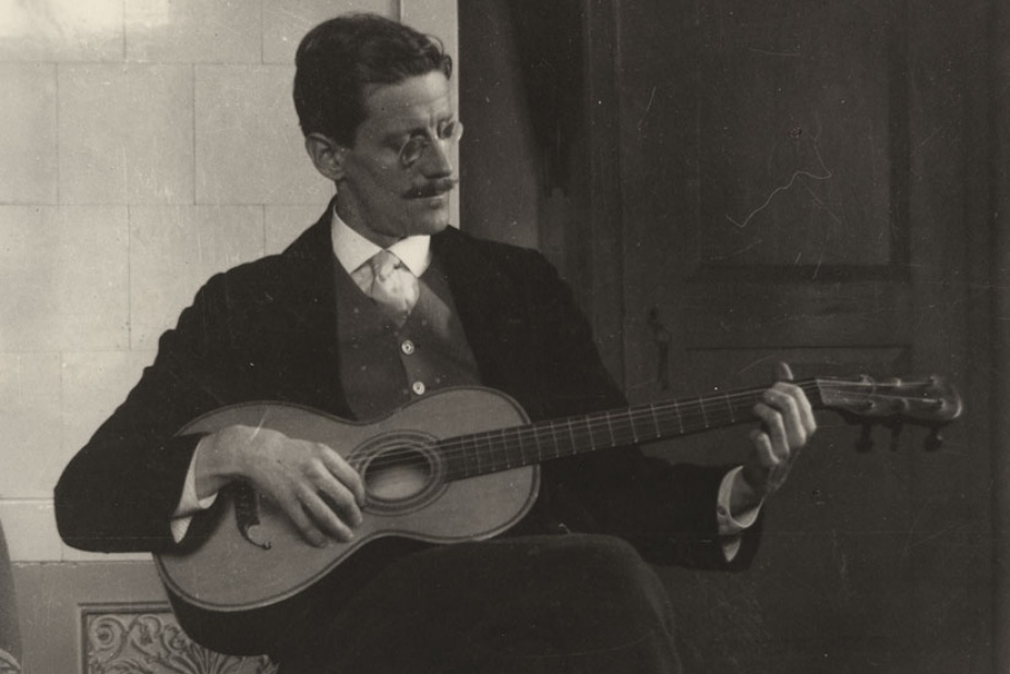 Photo of James Joyce playing the guitar. 