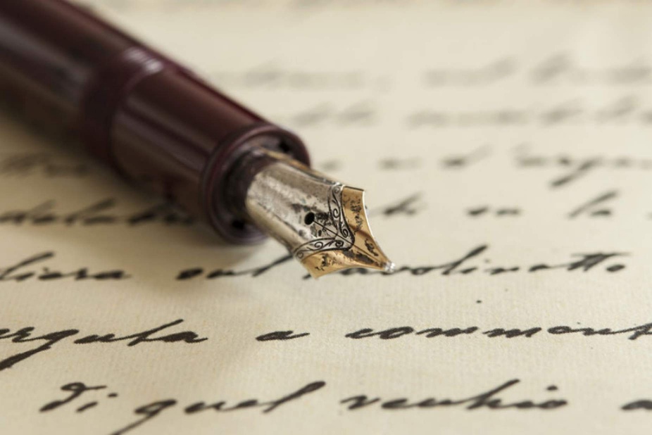 Pen rests on written paper. 