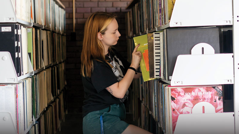 Student looking at vinyl records in the Music Library